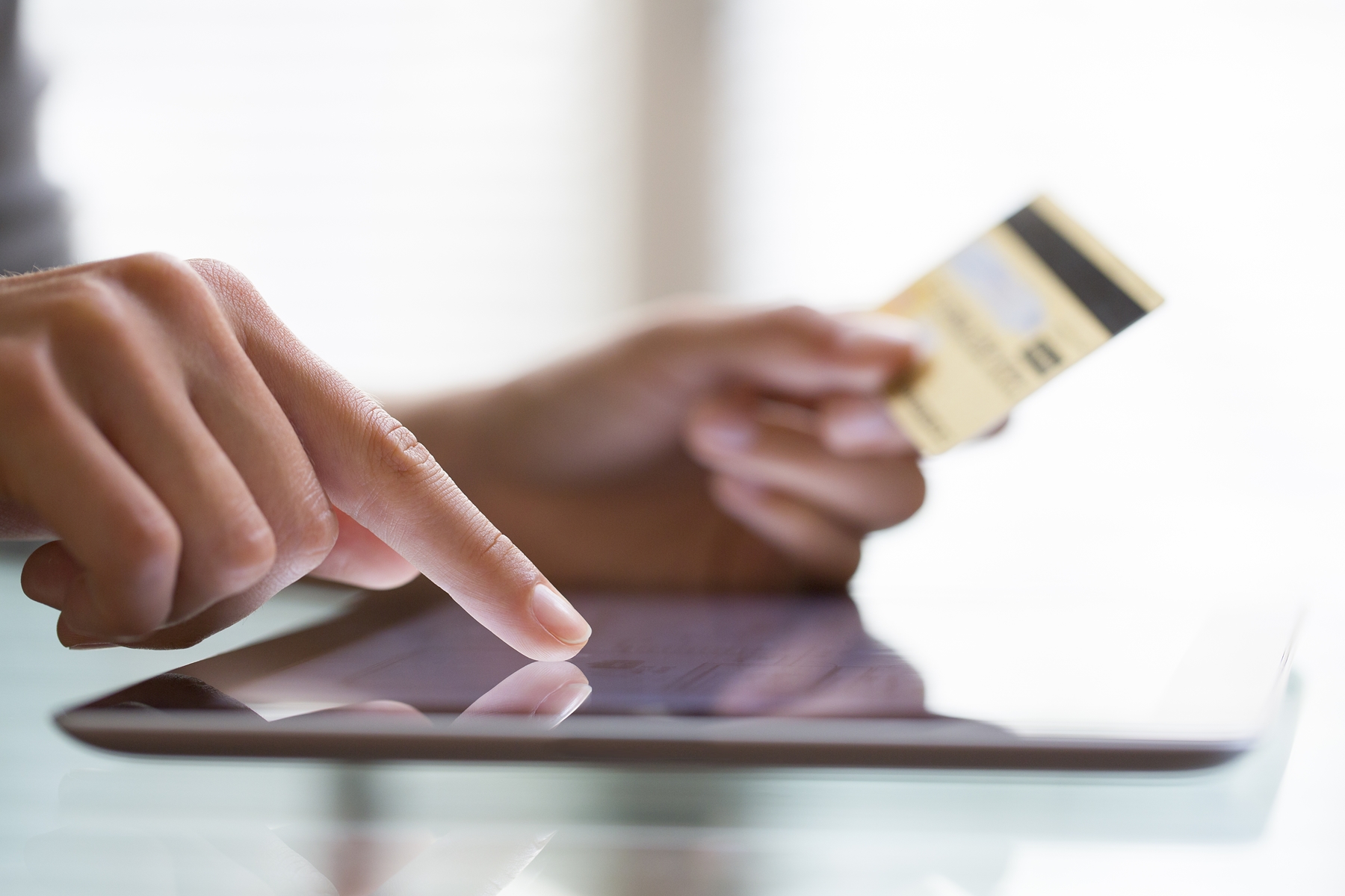 person holding credit card and working on a tablet