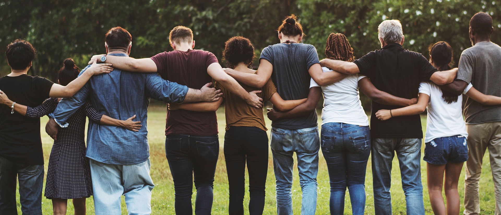 group of people standing in line with arms wrapped around one another