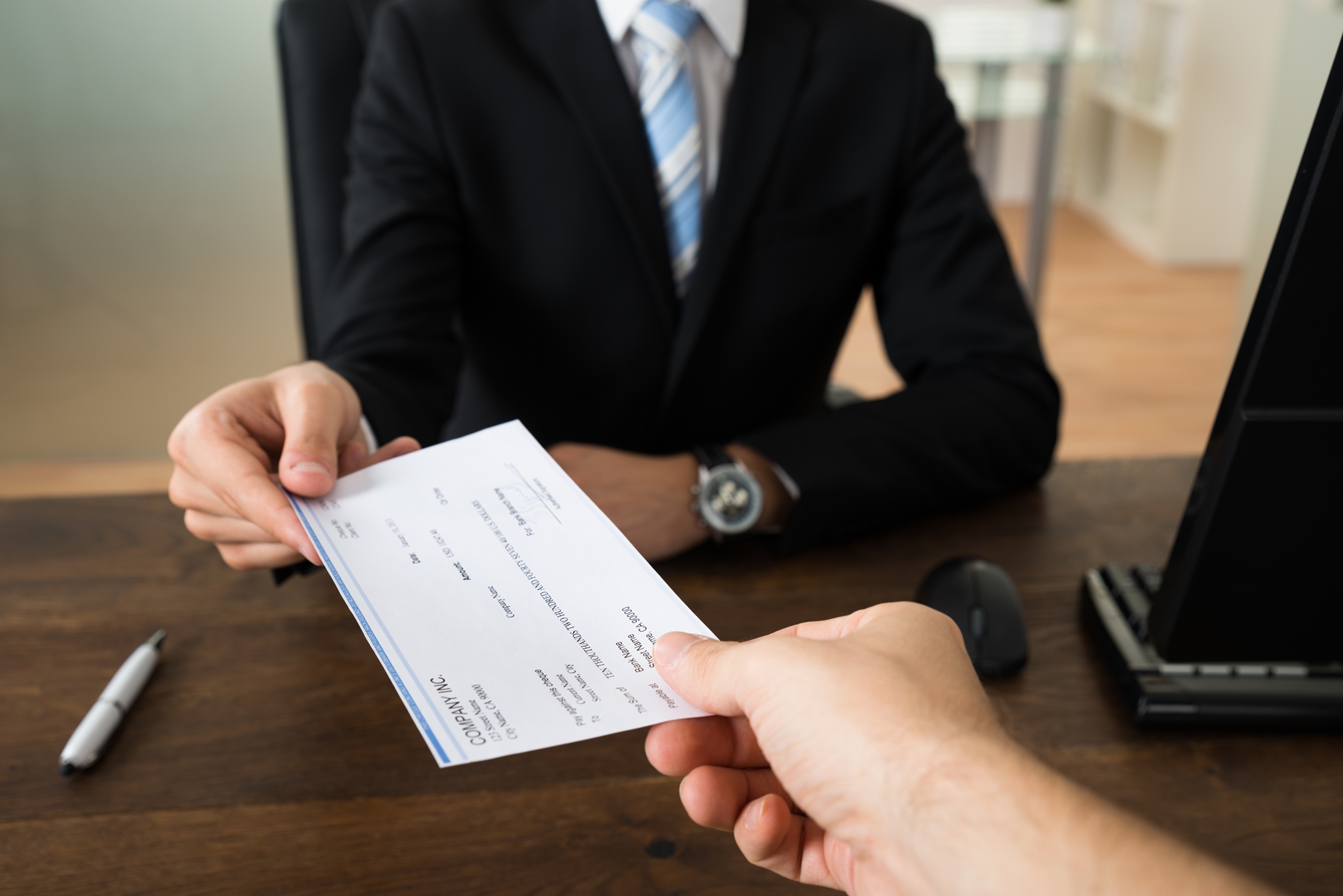 two people exchanging a check